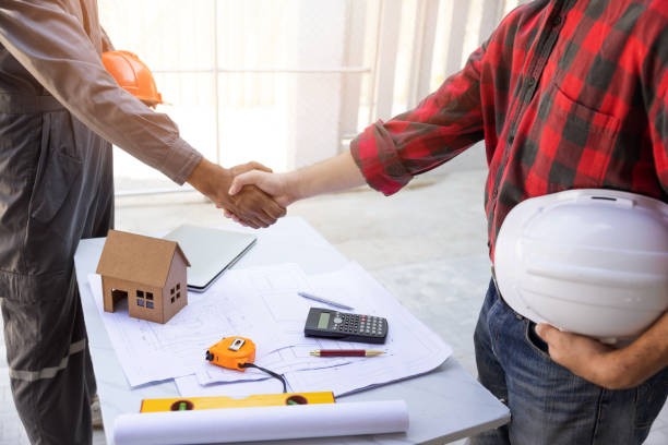 istock Construction concept of Engineer and Architect working at Construction Site with blue print, Engineer shaking hand with Architect 1462203709