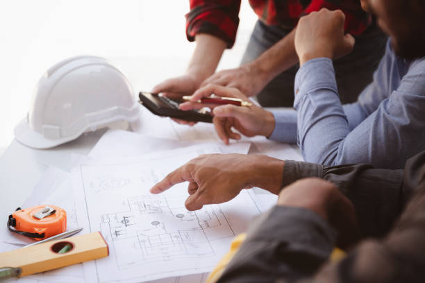 istock Construction concept of Engineer and Architect working at Construction Site with blue print, Engineer and Architect discussing construction plan with computer laptop calculator 1462203742