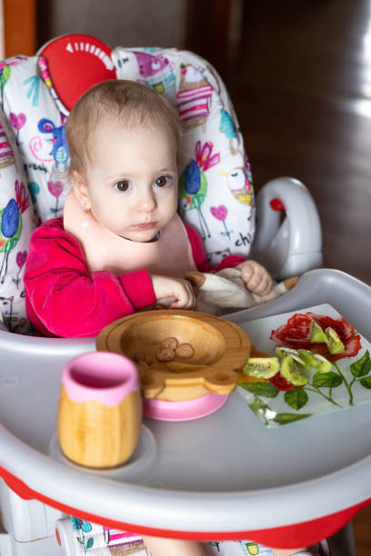 istock The baby eats from children's tableware made of wood. 1462204592