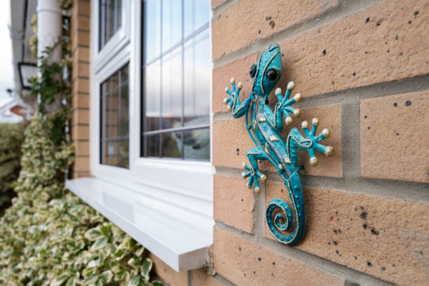 Ornate, metal lizard seen on a rear wall of a house. stock photo