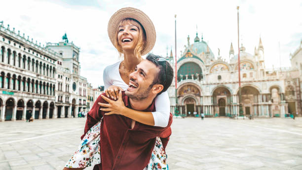 jovem casal romântico que desfruta de férias em veneza, itália - turistas felizes que visitam a cidade italiana nas férias de verão - turismo e conceito de estilo de vida - destino de viagem - fotografias e filmes do acervo