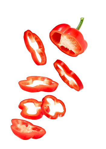 Red bell pepper cut into slices isolated on white background. Levitation