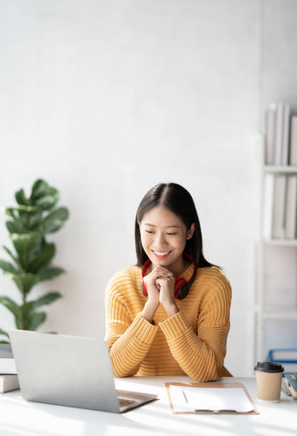 istock Young woman using laptop comfortably at home while studing for her project at school. 1462214503
