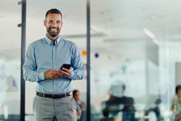 istock Happy male entrepreneur using cell phone in the office. 1462214539