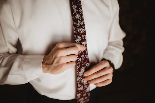 Groom on his wedding tie tying his tie