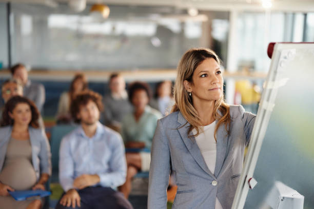 istock Young female CEO drawing plans during presentation in board room. 1462214948