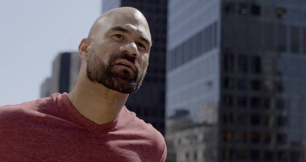 istock Handsome mixed race man looking thoughtfully at big city buildings 1462218026