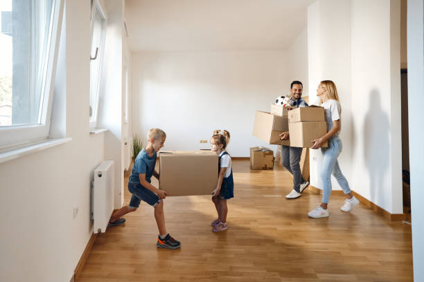 istock Happy family cooperating while carrying boxes in their new home. 1462218216