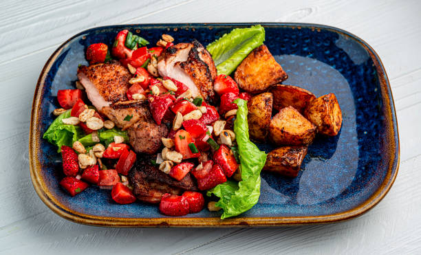 istock Duck breast with strawberries, tomatoes, nuts and baked potatoes 1462218500