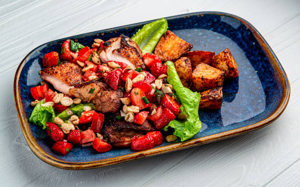 istock Duck breast with strawberries, tomatoes, nuts and baked potatoes 1462218507