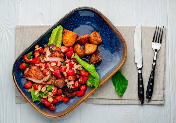 istock Duck breast with strawberries, tomatoes, nuts and baked potatoes 1462218527