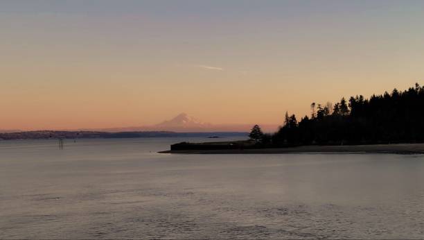 Sunset view on Mount Rainier A landscape view from Bainbridge Island of Mount Rainier covered in Sunset light. bainbridge island stock pictures, royalty-free photos & images