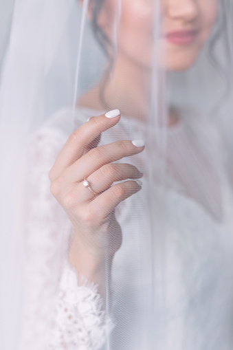 happy bride shows her hand where on her finger there is a ring with a beautiful diamond.