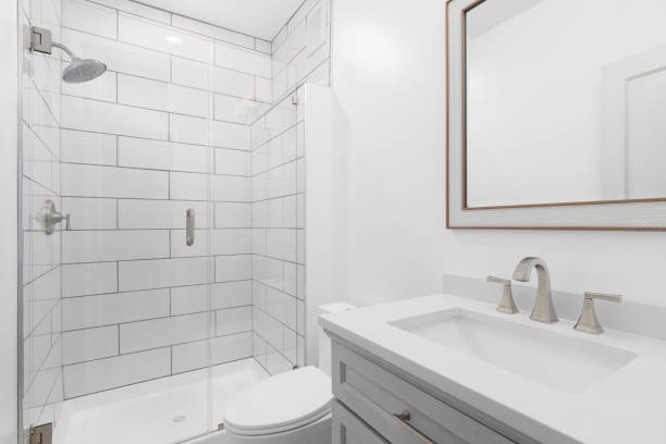 un baño con un gabinete gris y ducha alicatada. - baño fotografías e imágenes de stock