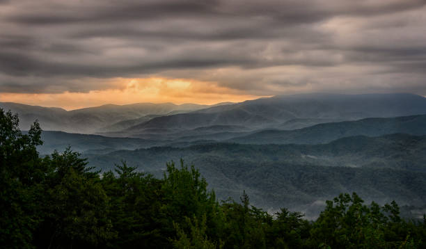 Sunrise over The Great Smoky Mountains Townsend, TN, USA – August 22, 2019.  Sunrise over the Great Smoky Mountains as seen from a scenic overlook on The Foothills Parkway in Eastern Tennessee.  Clouds, morning fog, mist and dramatic clouds, which give the Great Smoky Mountains their name, fill the beautiful scene at dawn. foothills parkway photos stock pictures, royalty-free photos & images