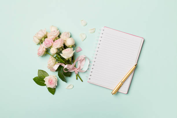 istock Notebook, gift box and rose flowers on color background, top view 1462229794