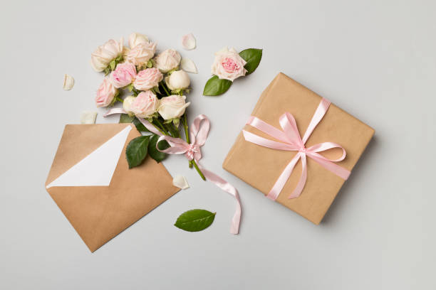 istock Envelope, gift box and rose flowers on color background, top view 1462229816