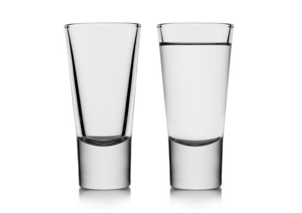 istock Classic empty and full shot glasses with tequila or vodka on white. 1462229898