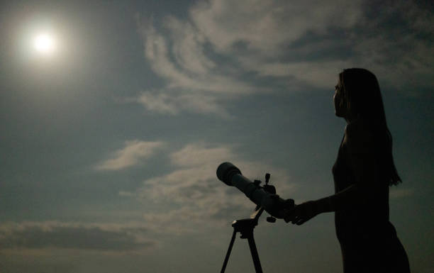 istock Woman with a telescope looking at the evening sky 1462237006