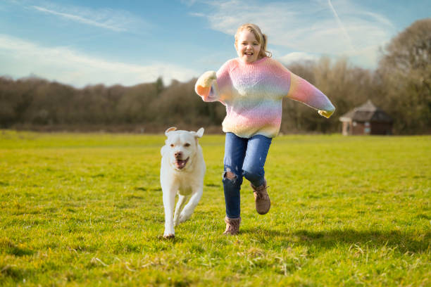 그녀의 개와 함께 달리는 어린 소녀 스톡 사진