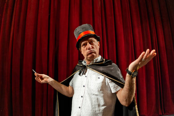 istock Magician doing magic trick with playing cards on the stage 1462253234