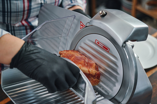 Food Safety - Slicing Ham on a Slicer Machine with Food Gloves