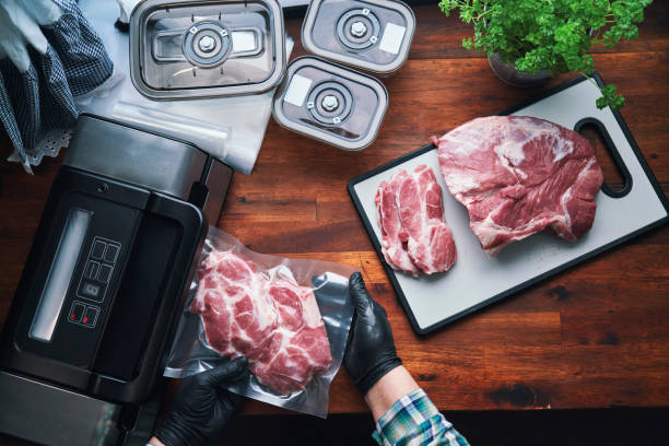 Food Safety - Preserving Fresh Pork Chops in a Plastic Bag with a Vacuume Sealer Food Safety - Preserving Fresh Pork Chops in a Plastic Bag with a Vacuume Sealer vacuum packed stock pictures, royalty-free photos & images