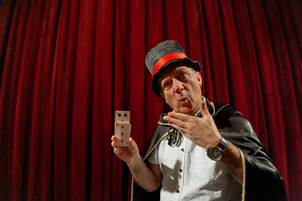 istock Magician doing magic trick with playing cards on the stage 1462255865