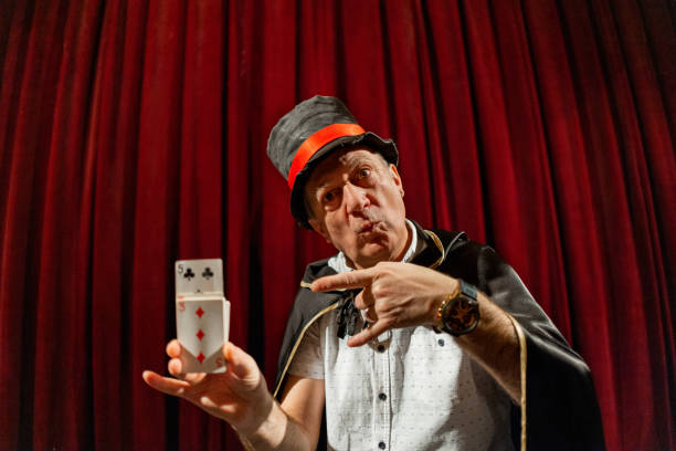 istock Magician doing magic trick with playing cards on the stage 1462256929