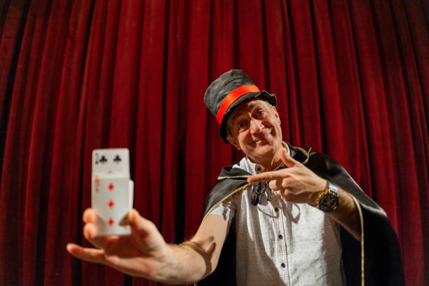 istock Magician doing magic trick with playing cards on the stage 1462256951