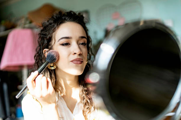 istock Young woman applying face powder with make-up brush 1462260773