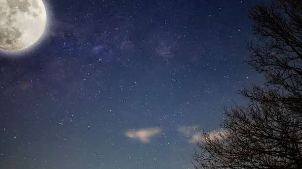 Photo of Night sky Milky way with full Moon and universe constellations in the background.