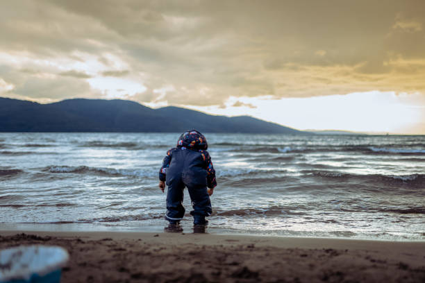 Little boy Making sand castle at bad weather