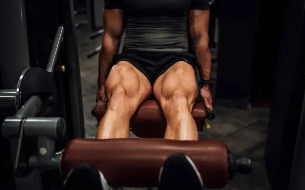 Young muscular man doing legs in the gym