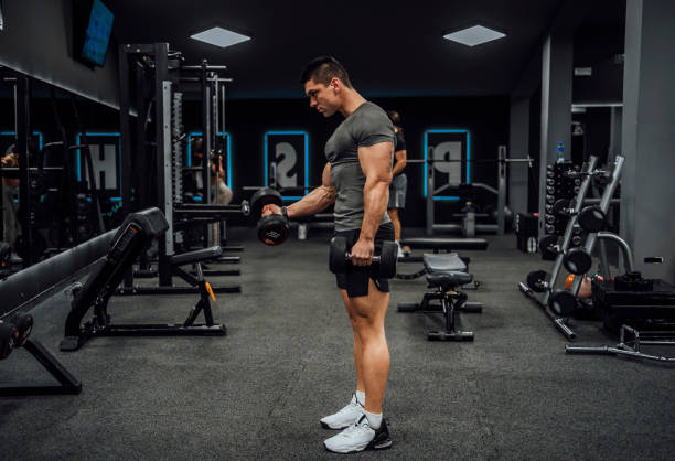 istock Muscular young man exercising with a dumbbells 1462280931