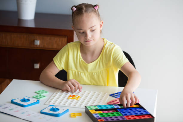 istock A girl with Down syndrome is preparing to go back to school. He does elementary mathematics. Performs logical tasks 1462280934