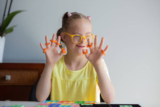 A girl with Down syndrome is preparing to go back to school. He does elementary mathematics. Performs logical tasks. Studying the Numicon.
