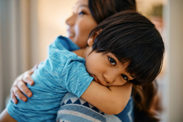 istock Sad Asian boy being consoled by his mother at home. 1462286162