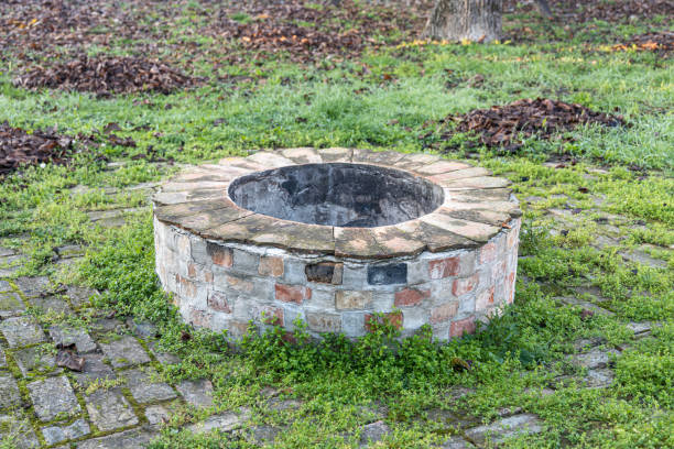 istock Gray and brown round fire hearth with orange bricks for a bonfire on green grass in a summer forest 1462286177