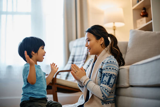 istock Happy Asian kid and his mother having fun while playing clapping game at home. 1462286178