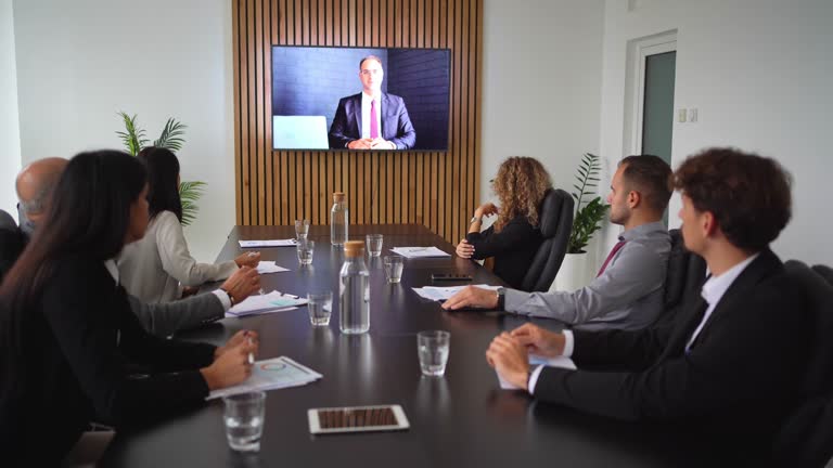 Business people looking at a screen during an online video conference in the conference room