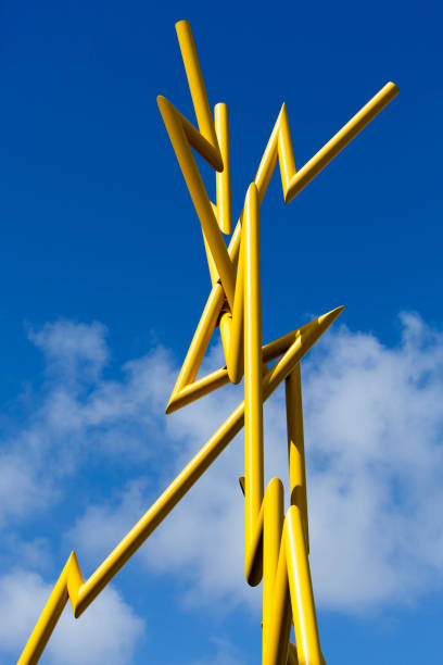Wooden frames forming a geometric pattern against a blue sky with clouds.