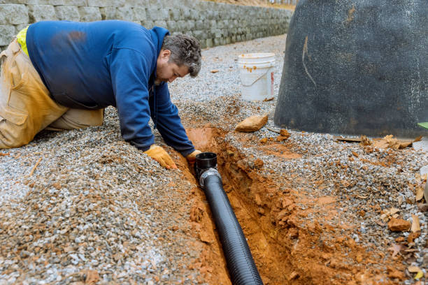 Assembling the drainage pipe for rain water that is going to be used for rain water collection on the covered parking space with gravel driveway stock photo