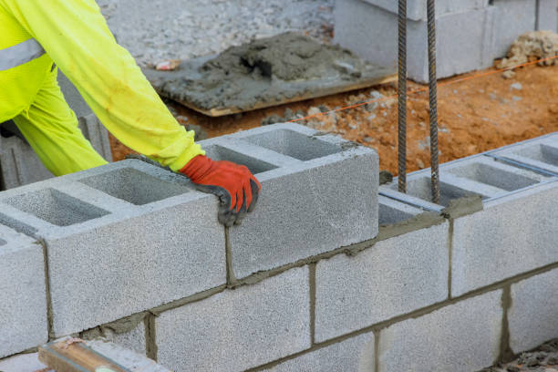 istock The bricklayer is putting down another row of cement blocks as part of the construction process 1462297004