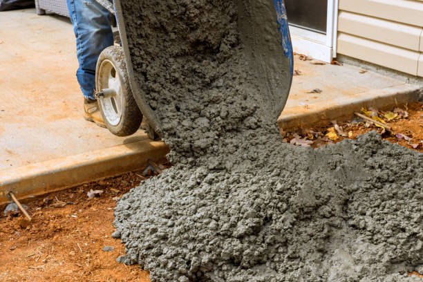 istock A construction worker pours cement from a wheelbarrow into a concrete sidewalk created on the side of a house using cement from a wheelbarrow 1462297005