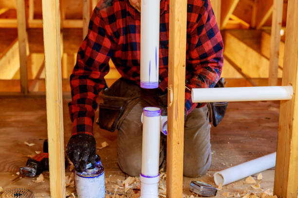 istock Using cement glue, a plumber joins plastic pipes using a PVC pipe and puts glue on it for residential home construction 1462297055