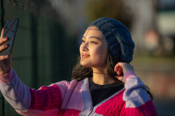 istock Young girl is taking a selfie at sunset. 1462301850