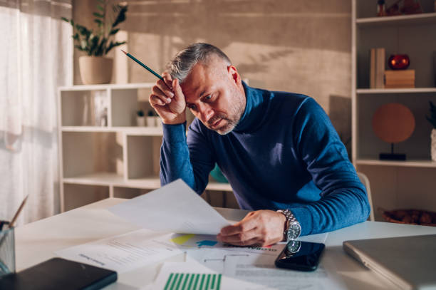 istock Gray haired middle aged man working in a home office 1462312311