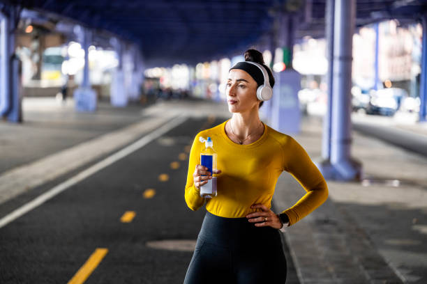 a woman drinking water during fitness activity in new york city - east river audio imagens e fotografias de stock