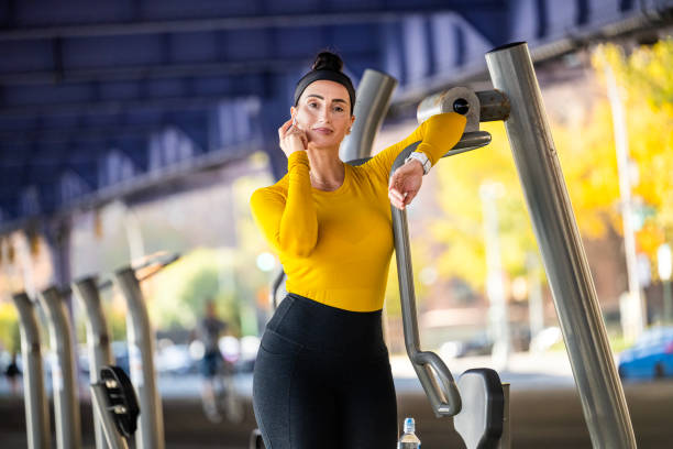 a fit woman in yellow sport shirt relaxing after fitness activity in new york city - east river audio imagens e fotografias de stock